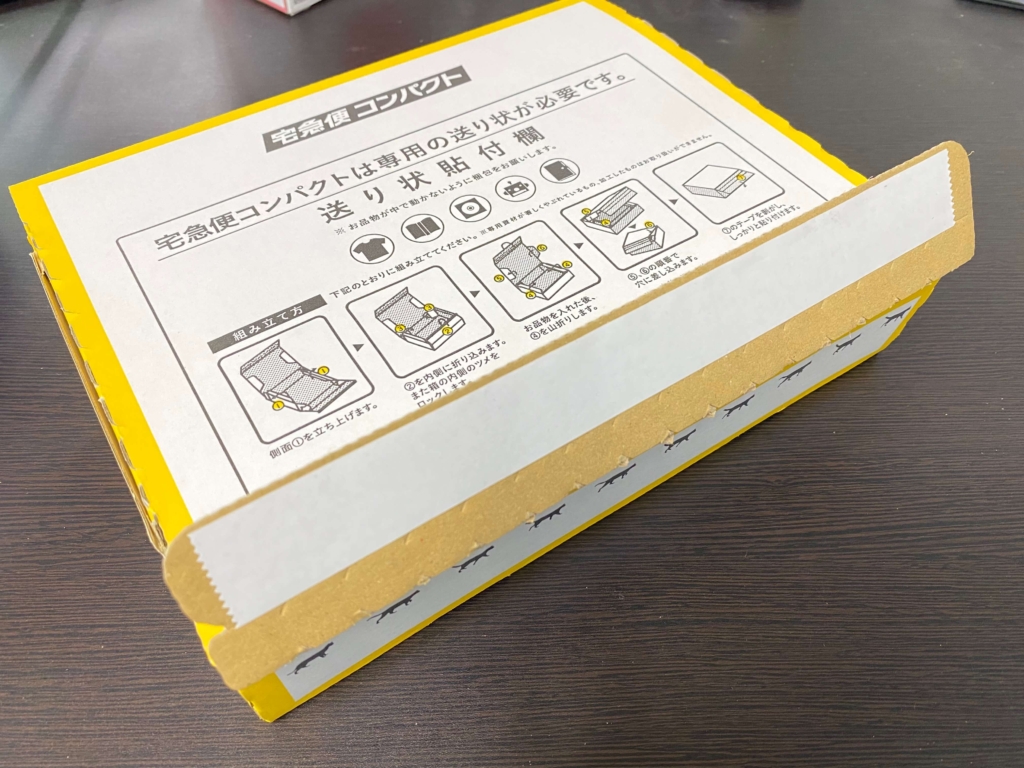 宅急便コンパクトBOXの両面テープを剥がして貼る